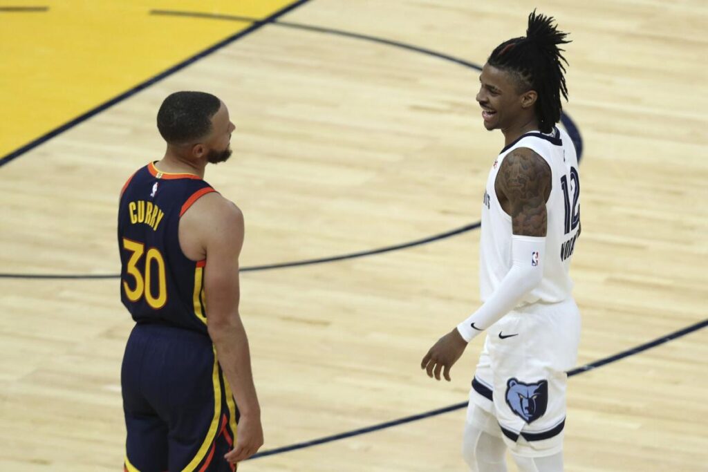 Ja Morant of the Memphis Grizzlies smiles with Stephen Curry.