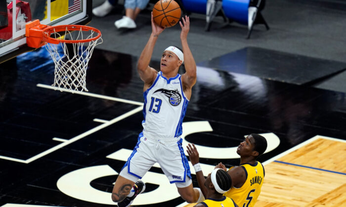 Orlando Magic guard R.J. Hampton (13) shoots over Indiana Pacers guard Caris LeVert, lower left, and guard Edmond Sumner (5) during the first half of an NBA basketball game, Friday, April 9, 2021, in Orlando, Fla. (AP Photo/John Raoux)