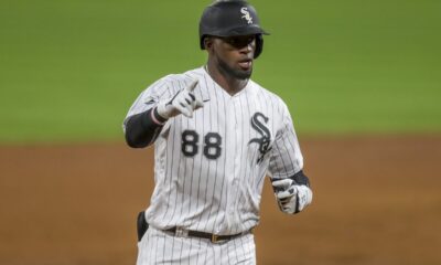 Chicago White Sox OF Luis Robert celebrates a double by pointing to his teammates in the dugout.