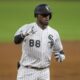 Chicago White Sox OF Luis Robert celebrates a double by pointing to his teammates in the dugout.