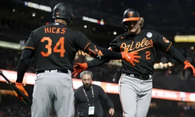 Gunnar Henderson prepares to high five Aaron Hicks during a road game for the Baltimore Orioles.