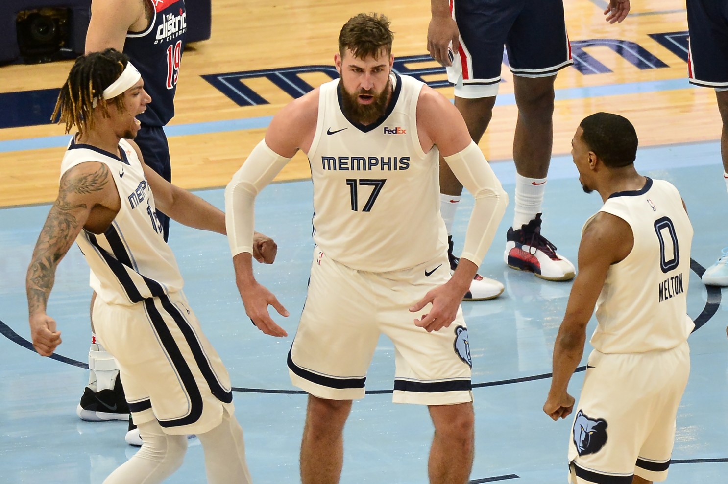 Memphis Grizzlies center Jonas Valanciunas (17) reacts with teammates Brandon Clarke (15) and De’Anthony Melton (0) after scoring in the second half of an NBA basketball game against the Washington Wizards Wednesday, March 10, 2021, in Memphis, Tenn. (AP Photo/Brandon Dill)