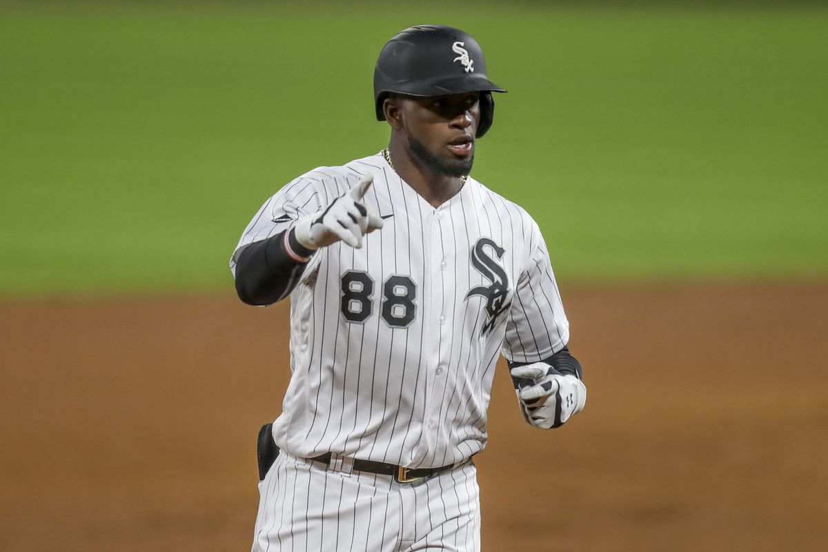 Chicago White Sox OF Luis Robert celebrates a double by pointing to his teammates in the dugout.