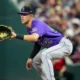 Nolan Jones waits to catch the ball at first base while playing for the Colorado Rockies against the Cincinnati Reds.