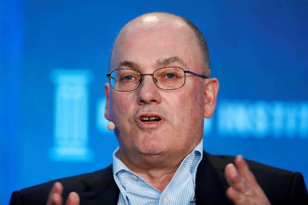 Steve Cohen speaks into a microphone at a business summit.