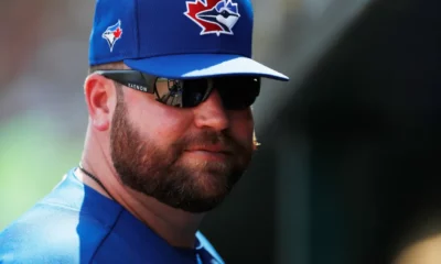 Toronto Blue Jays manager John Schneider stands in the dugout.