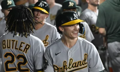 Zack Gelof smiles in the dugout after hitting a home run for the Oakland A's on the road.