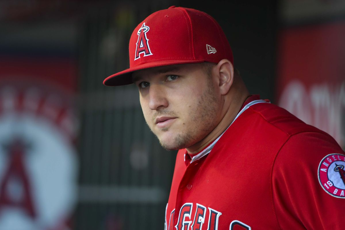 Mike Trout stand in the dugout during a game for the Los Angeles Angels.