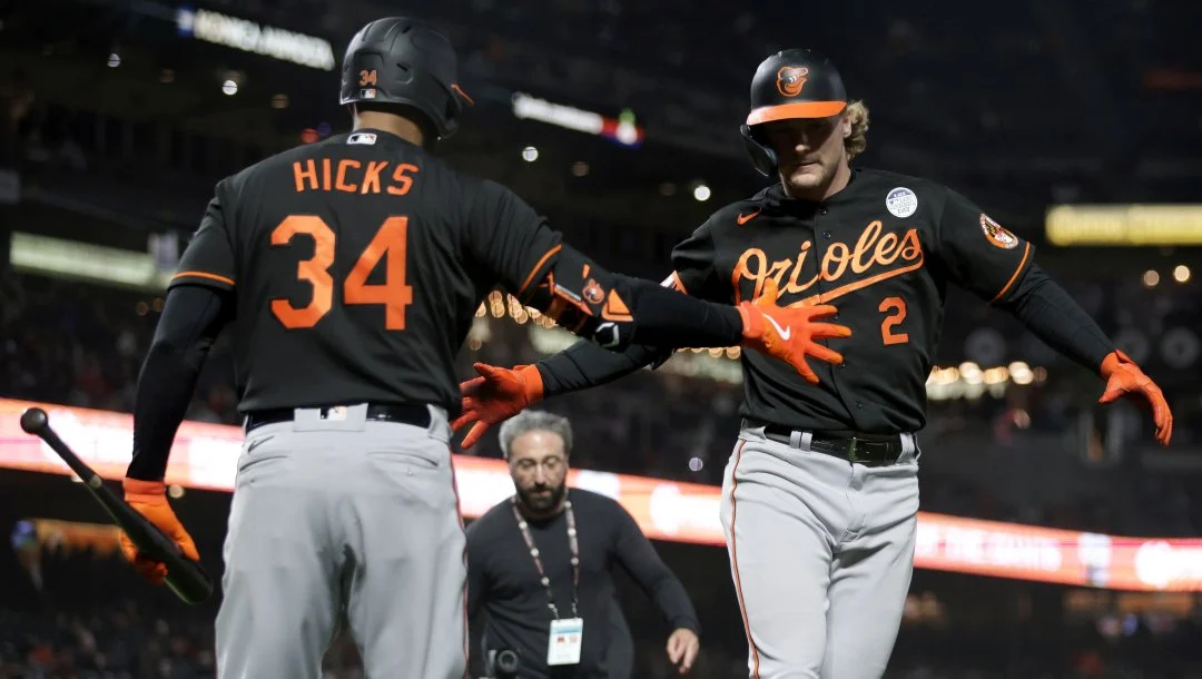 Gunnar Henderson prepares to high five Aaron Hicks during a road game for the Baltimore Orioles.