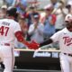 Edouard Julien and Byron Buxton high-five after a home run during a home game for the Minnesota Twins.