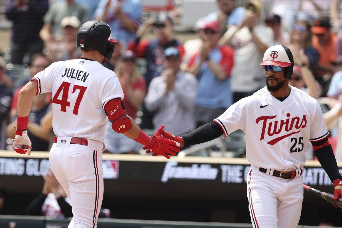 Edouard Julien and Byron Buxton high-five after a home run during a home game for the Minnesota Twins.