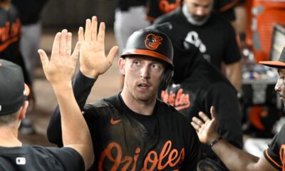 Jordan Westburg high fives his teammates in the Baltimore Orioles dugout.