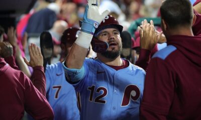 Kyle Schwarber high fives his teammates in the Philadelphia Phillies dugout.