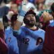 Kyle Schwarber high fives his teammates in the Philadelphia Phillies dugout.