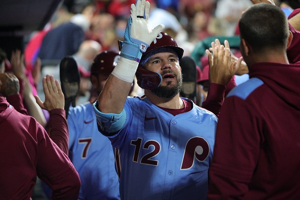 Kyle Schwarber high fives his teammates in the Philadelphia Phillies dugout.